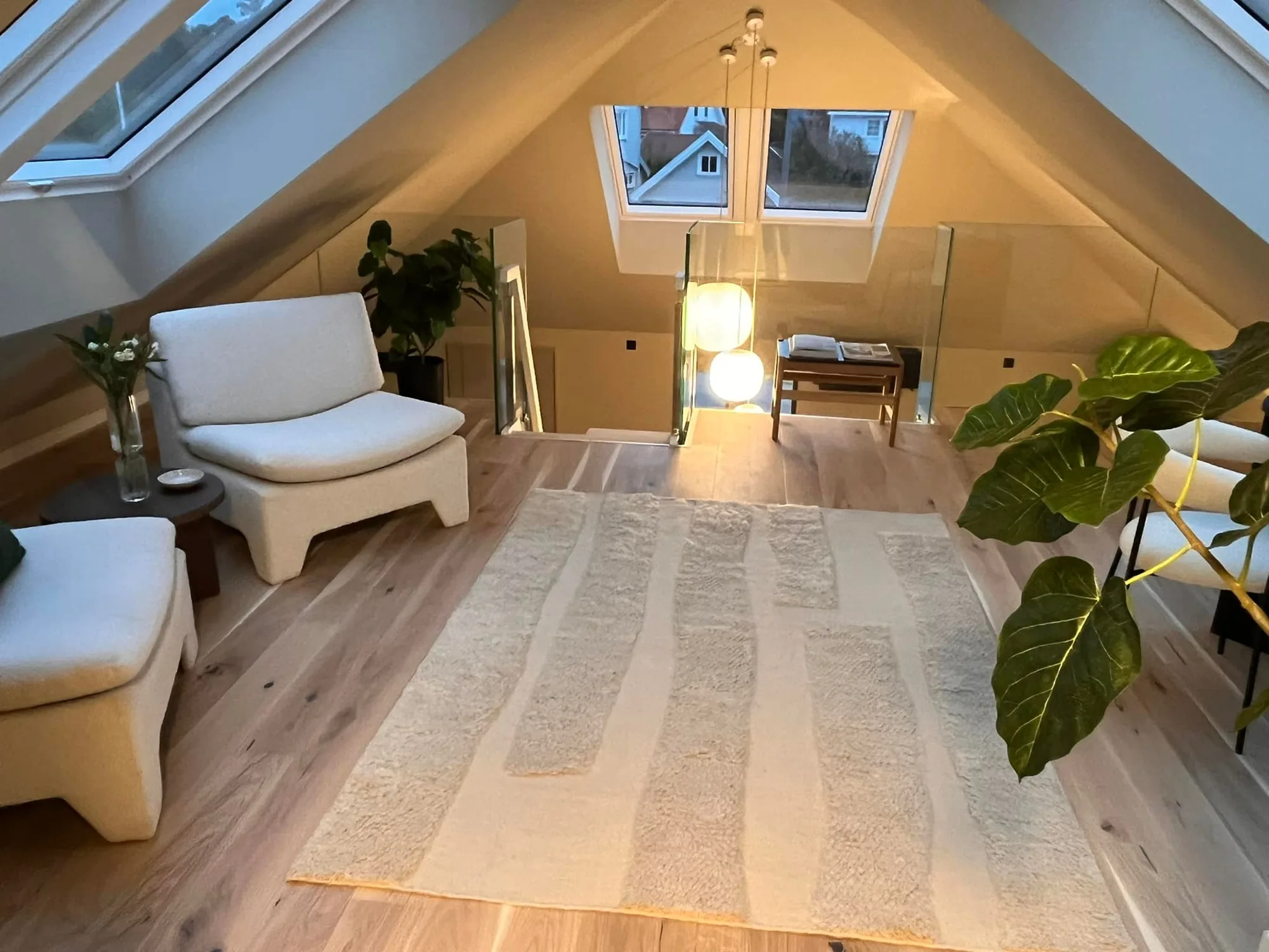 Lys loftsstue med takvinduer og eikegulv i en firemannsbolig Botnebygg har totalrenovert